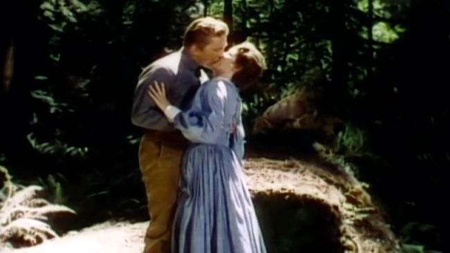Kirk Douglas and Ellen Corby kissing in the middle of the woods