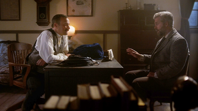 Bat Masterson talks with a Western legend from Wild West Chronicles in a cozy western style room.