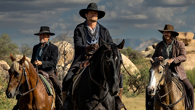 Three cowboys on horseback.